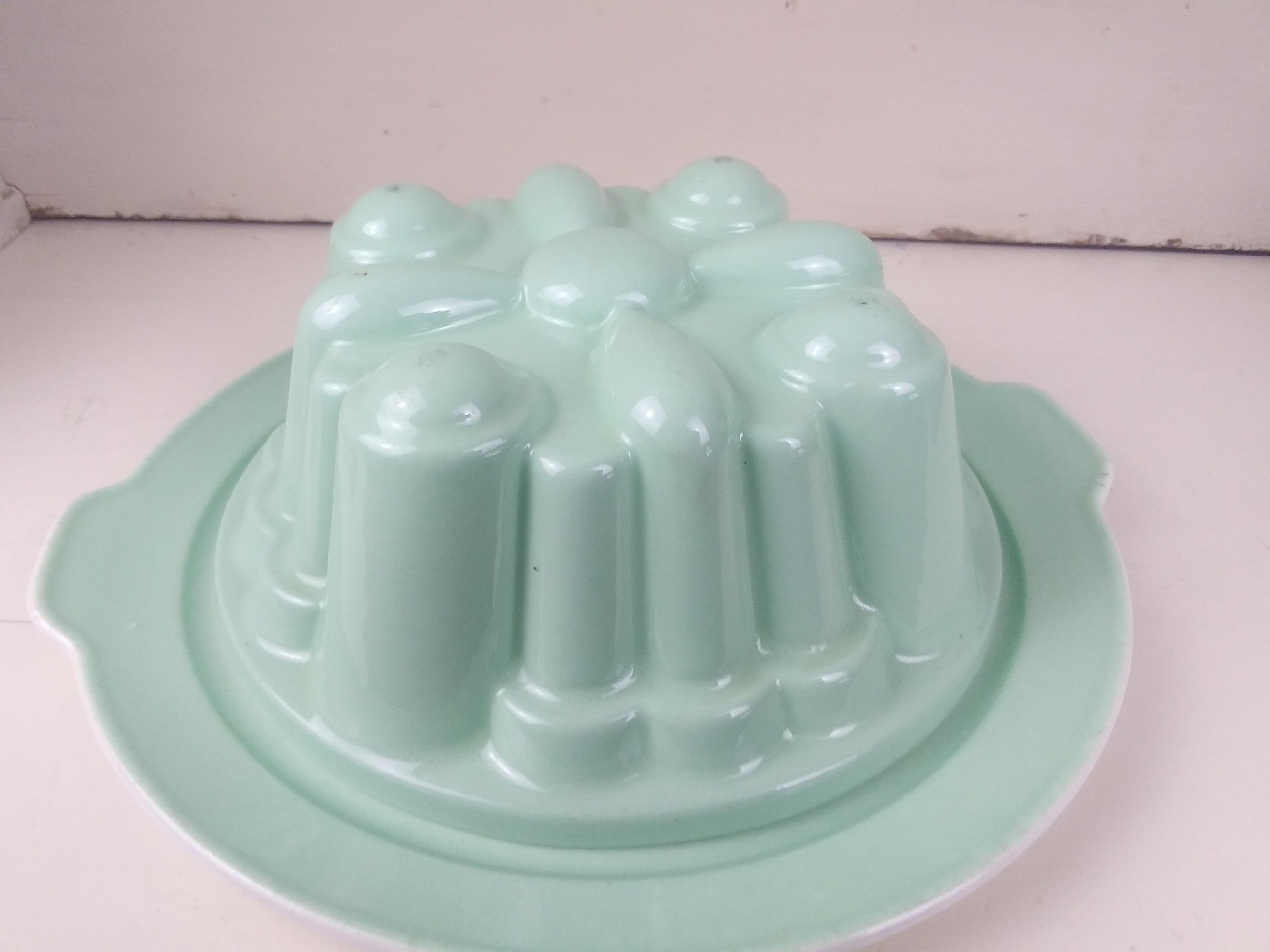 Grote oude puddingvorm op onderbord-Minrgroen